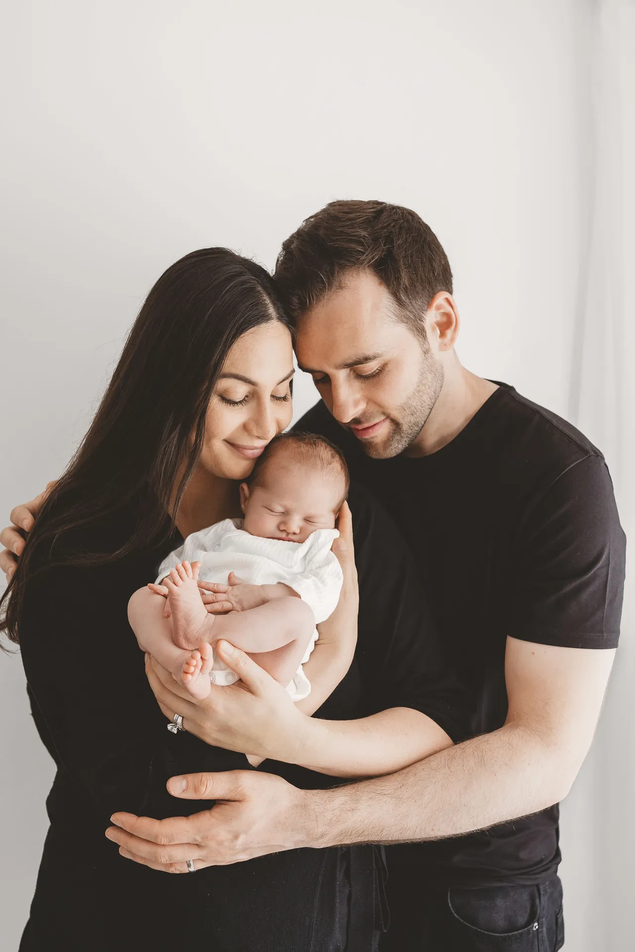 Family portrait of parents holding their newborn baby