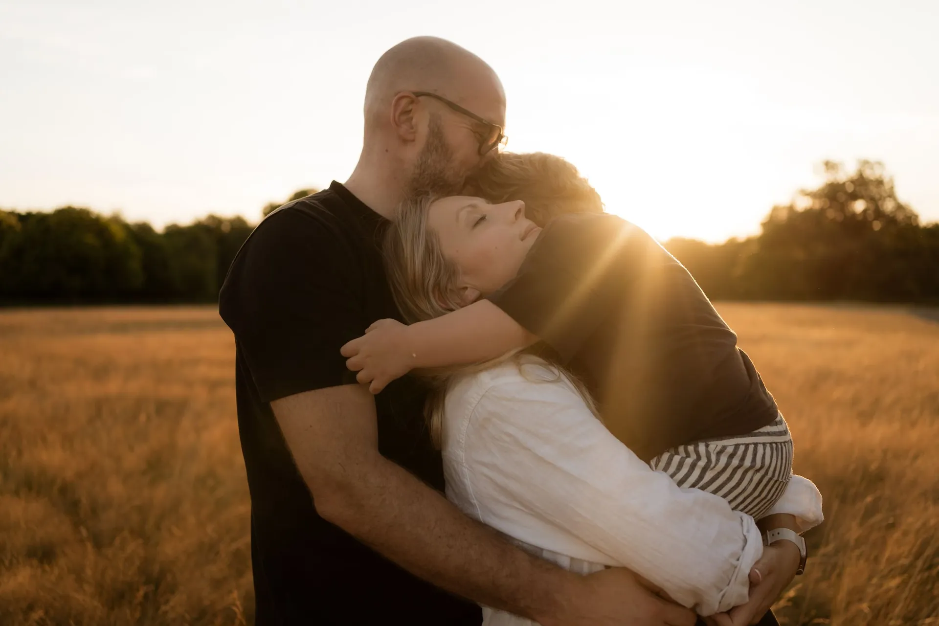 Family outdoor photography Surrey - parents with children and dog at golden hour