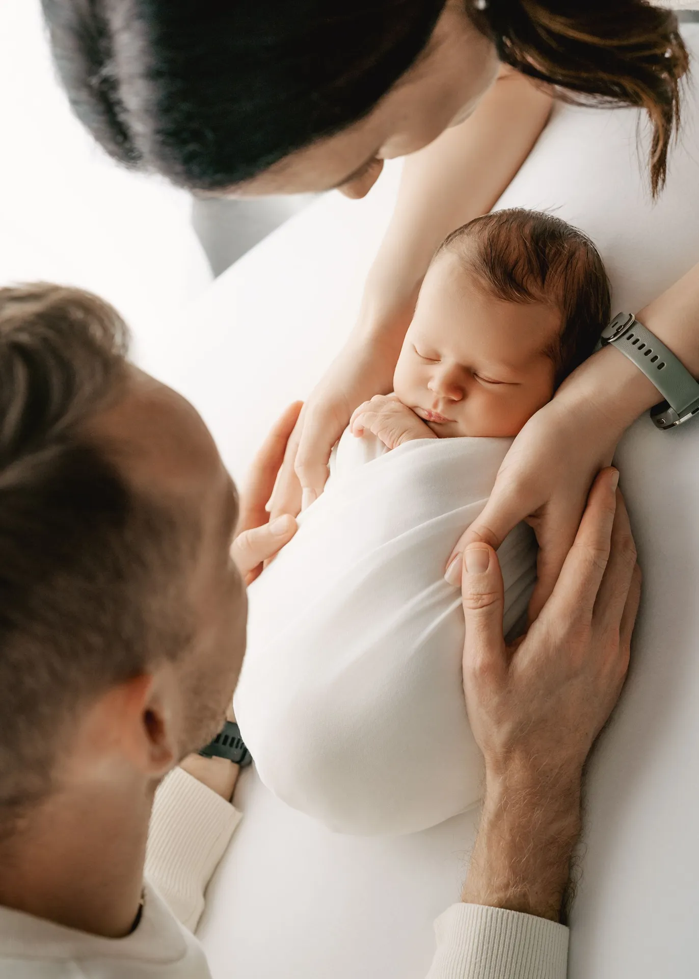 Newborn baby sleeping peacefully while being held by caring hands